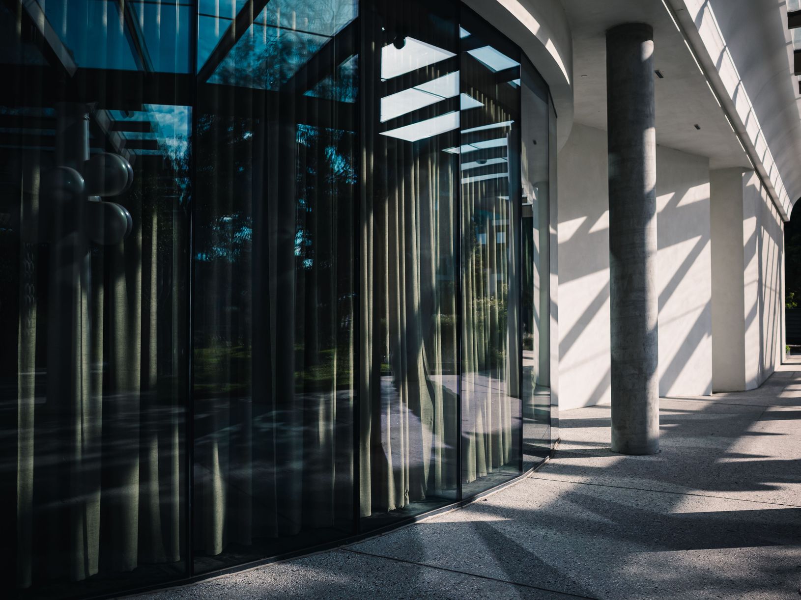 Glass corridor of a commercial building featuring professional window tinting film in New Jersey