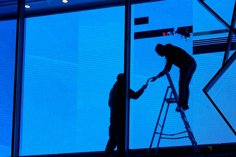 Window tinting installer working on a commercial building window at night in New Jersey