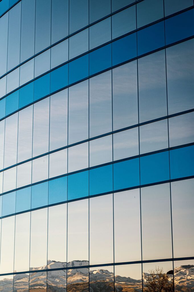 Reflective blue glass facade of a commercial building with window tinting in New Jersey