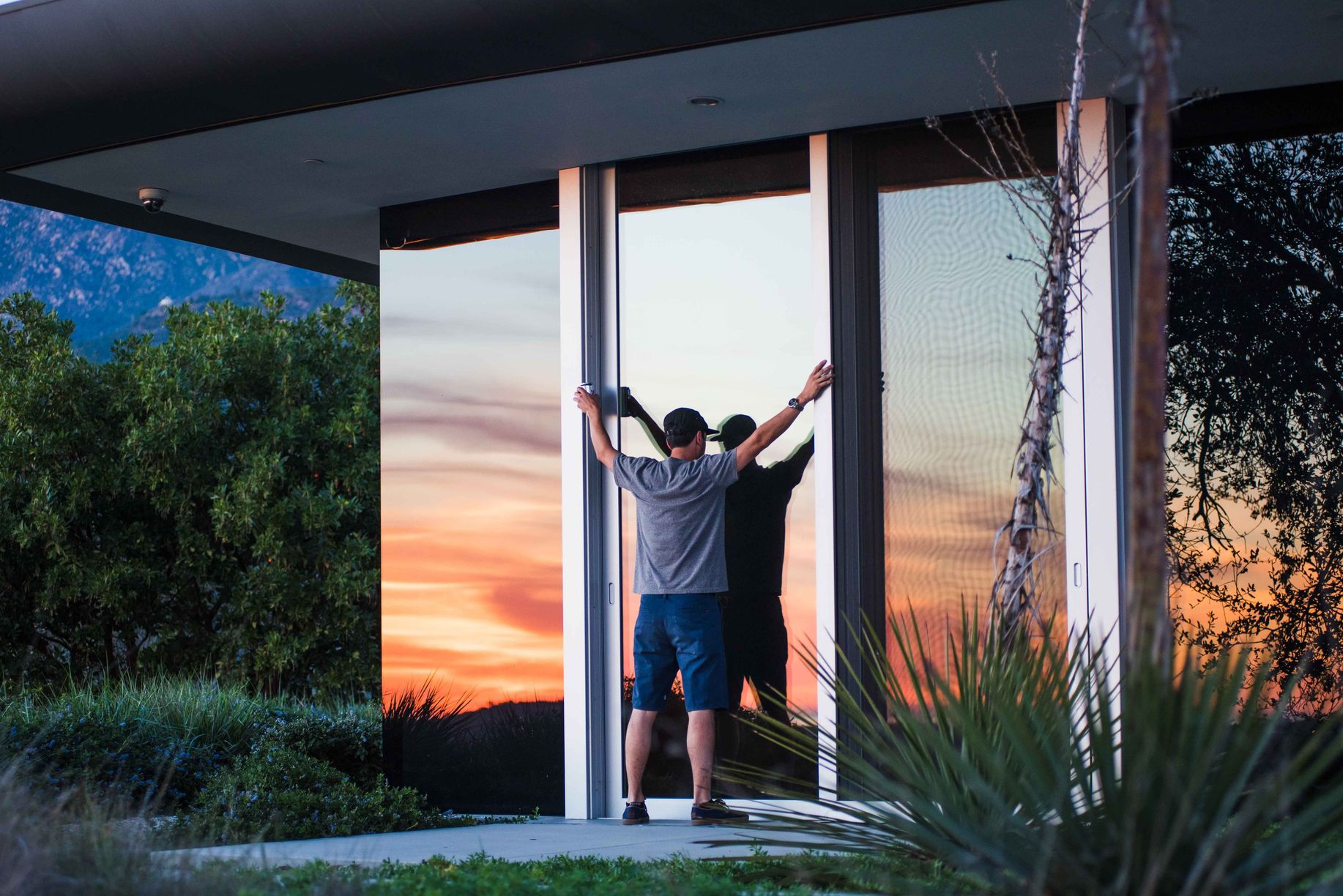 Homeowner enjoying sunset view through tinted windows after home window tinting in Old Bridge NJ
