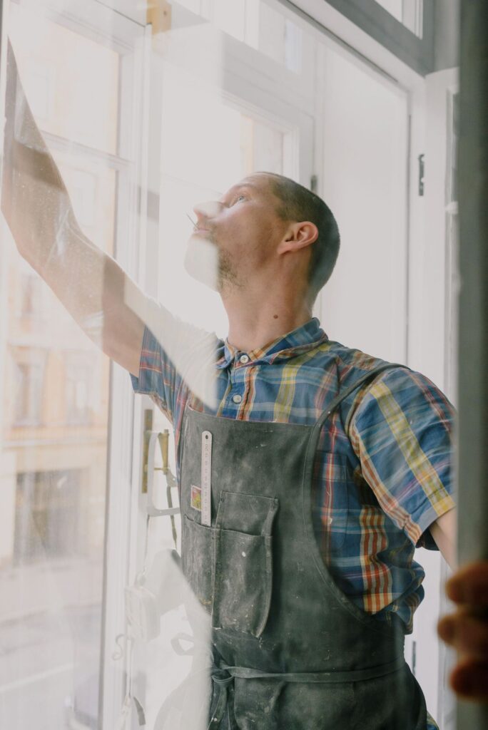 Mobile window tinting technician installing film on a home window in New Jersey