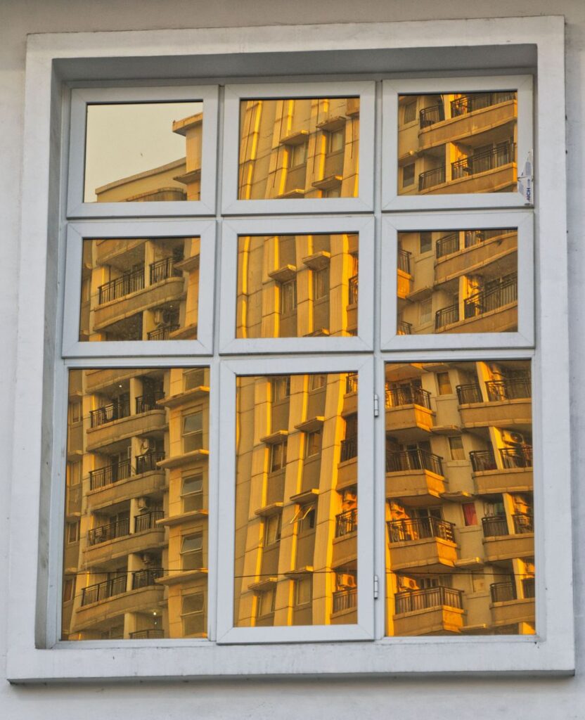 Home window with warm golden light showing residential window tinting film in NJ
